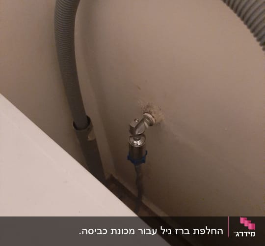 צינור גמיש וברז מתכת על קיר